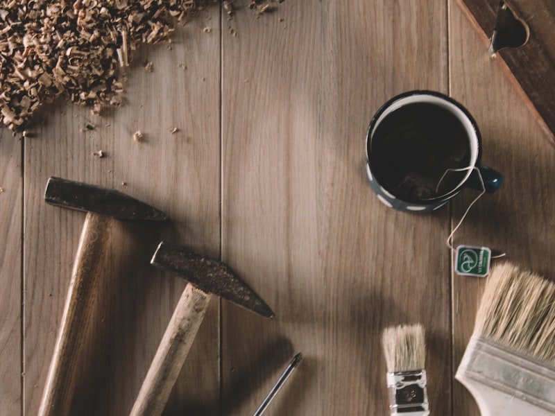 Hammers, wood shavings and workshop coffee on a warm wood bench